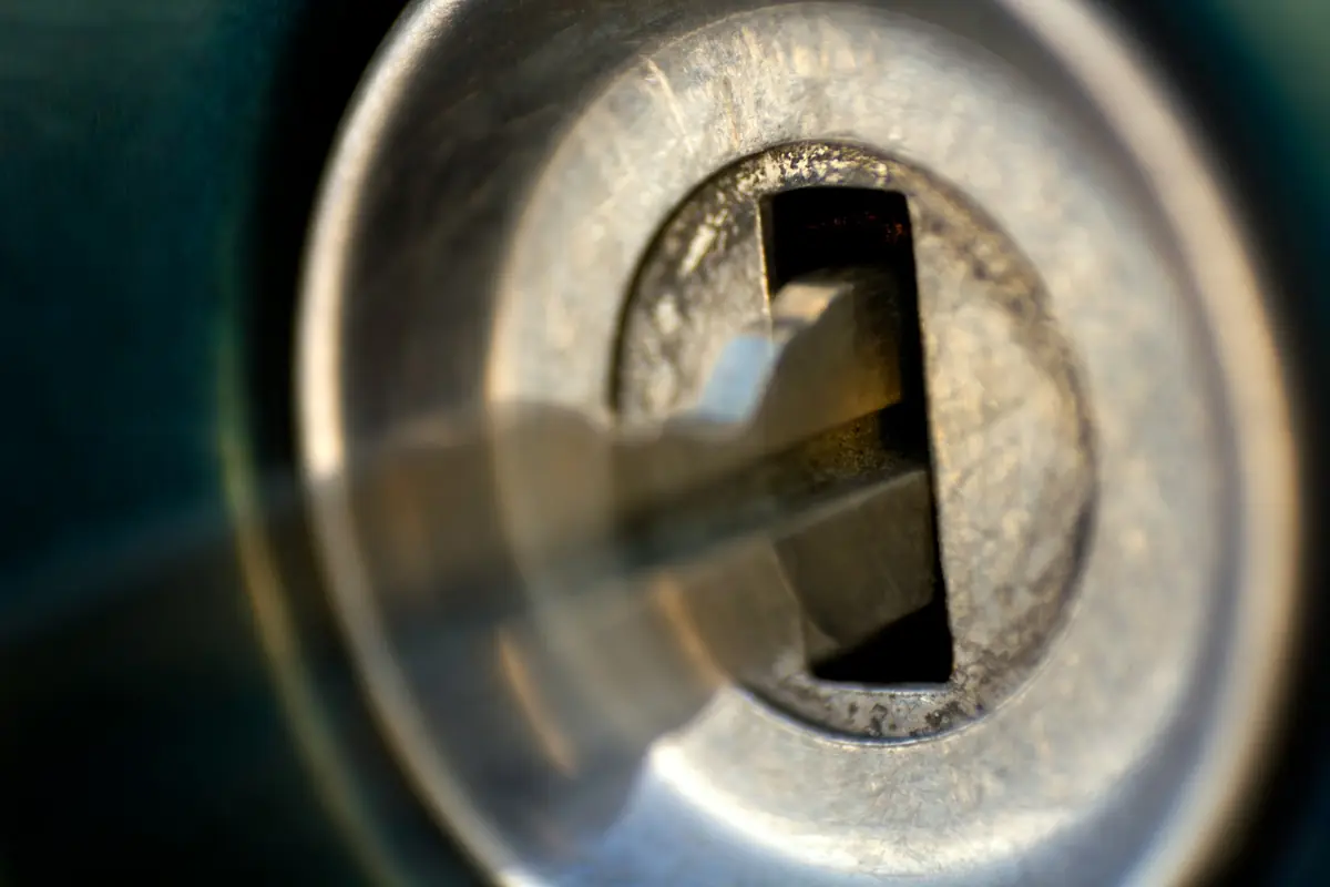 Close-up of a key inserted in a metal lock cylinder
